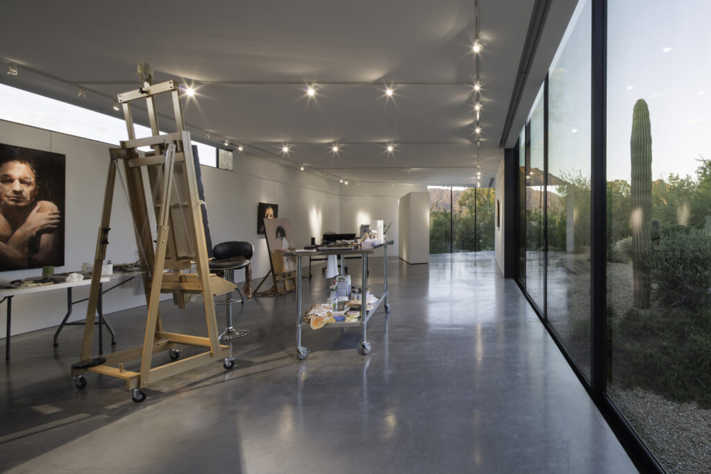 Art studio lighting that complements the natural light coming through the floor to ceiling windows