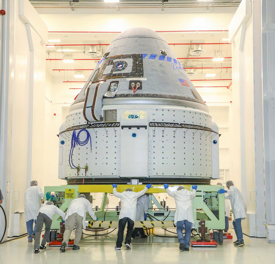 Engineers push the CST-100 Starliner spacecraft into the Commercial Crew and Cargo Processing Facility at the Kennedy Space Center in Floria.