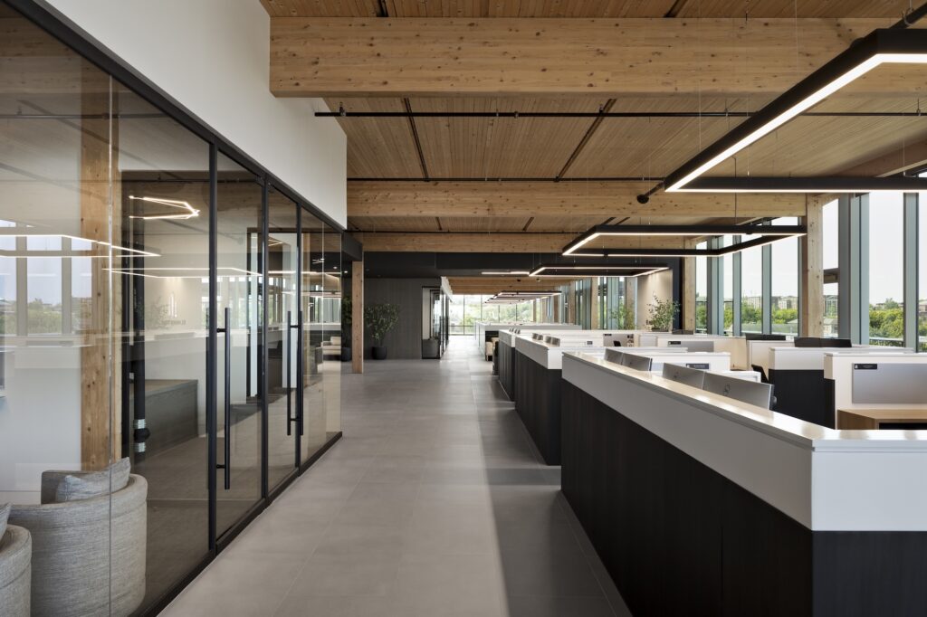 Square LED pendant lights light workspaces in an open floor plan office