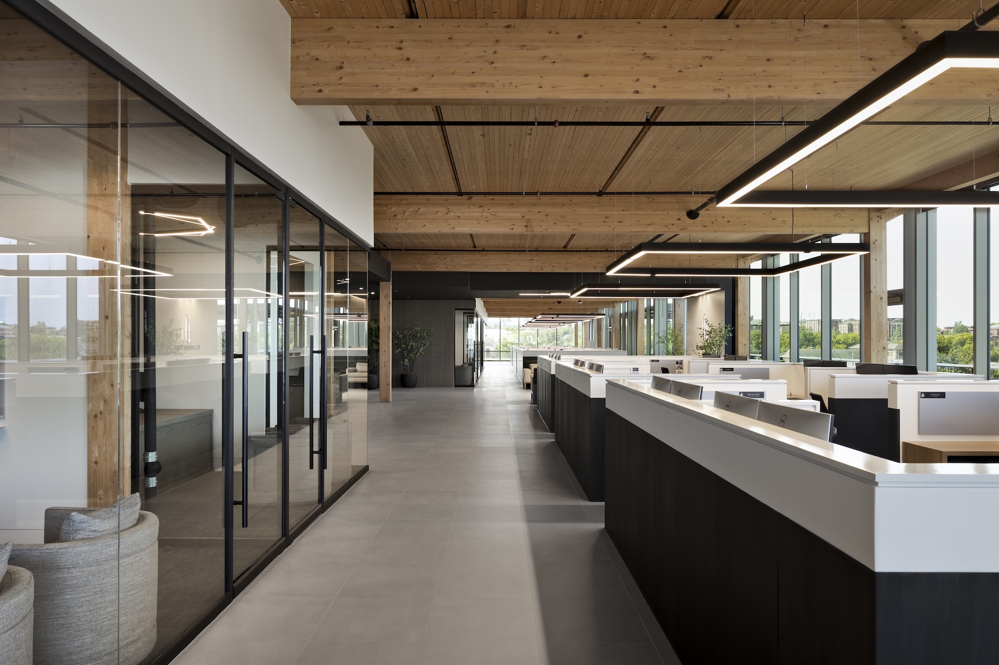 Square LED pendant lights light workspaces in an open floor plan office