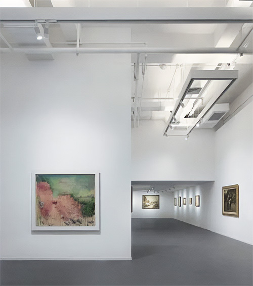 Rectangular track channels suspended from the ceiling of an art gallery hold white monopoint track lights positioned to light wall art.