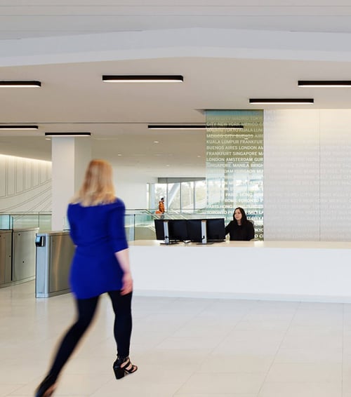 Mounted on an office lobby’s cream ceiling, these black LED linear ceiling lights stand out.
