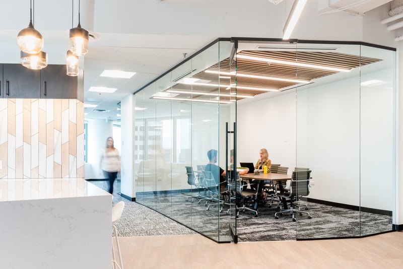 An office conference room at the Tabor Center in Denver, Colorado with a slatted wooden ceiling fitted with linear recessed LED lights