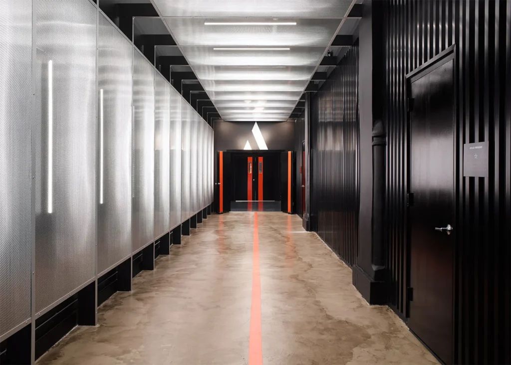 The Hall of Champions at the AARMY fitness studio features linear lighting that creates an atmosphere of entering an arena
