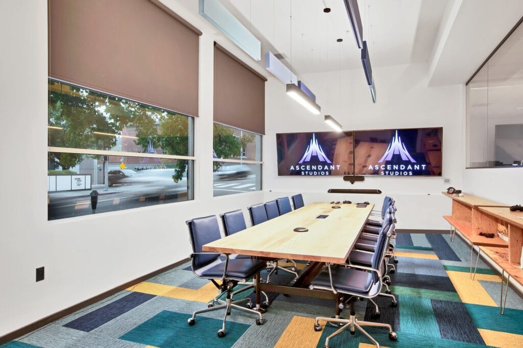 Tunable white linear LED pendant lights suspended over a conference room table.