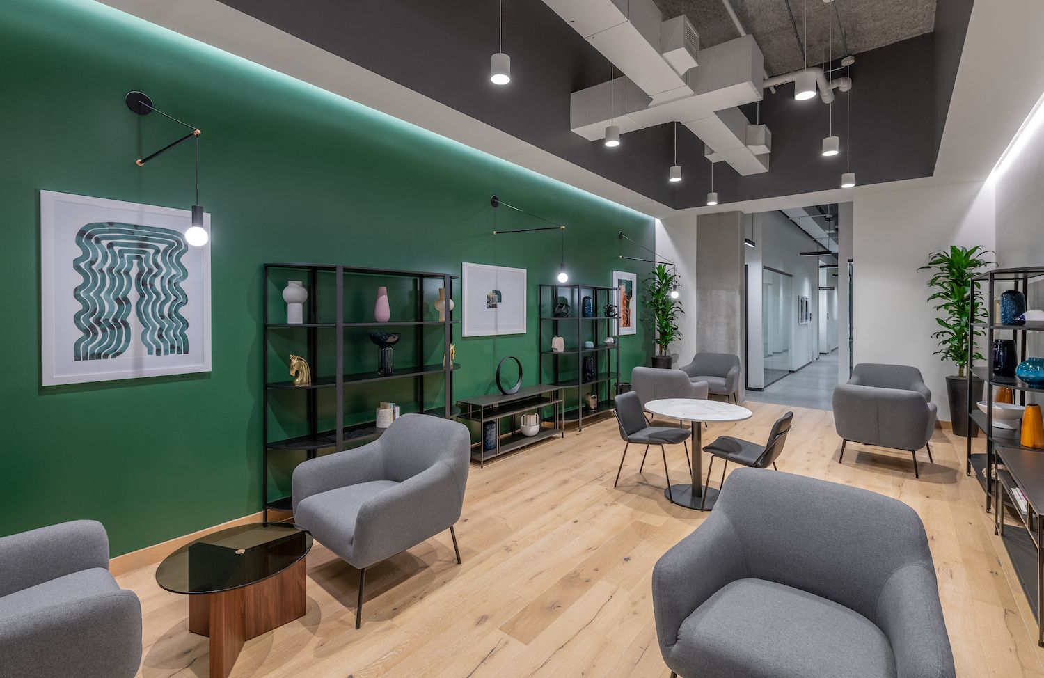 Perimeter lighting, cylinder downlights and bulb pendants provide layered lighting in an office lounge.