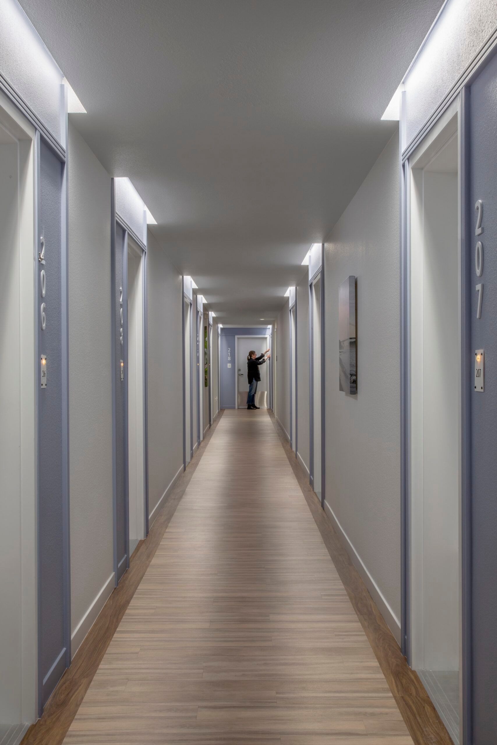 Fixed-length cove lights set above doorways illuminate entries and apartment numbers.