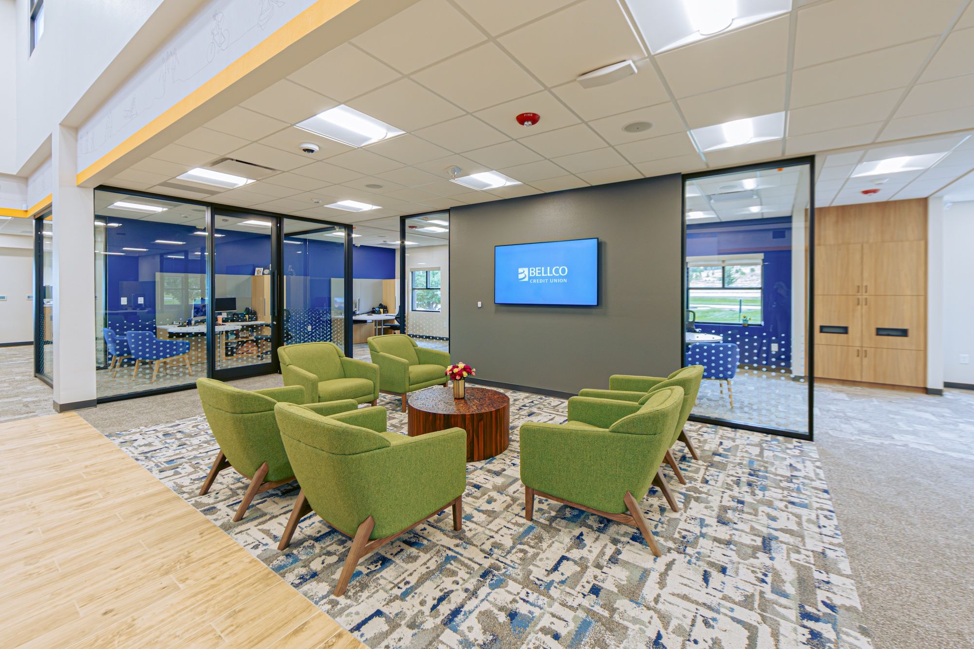 Bellco Credit Union lobby features troffer lights and emergency exit lighting.