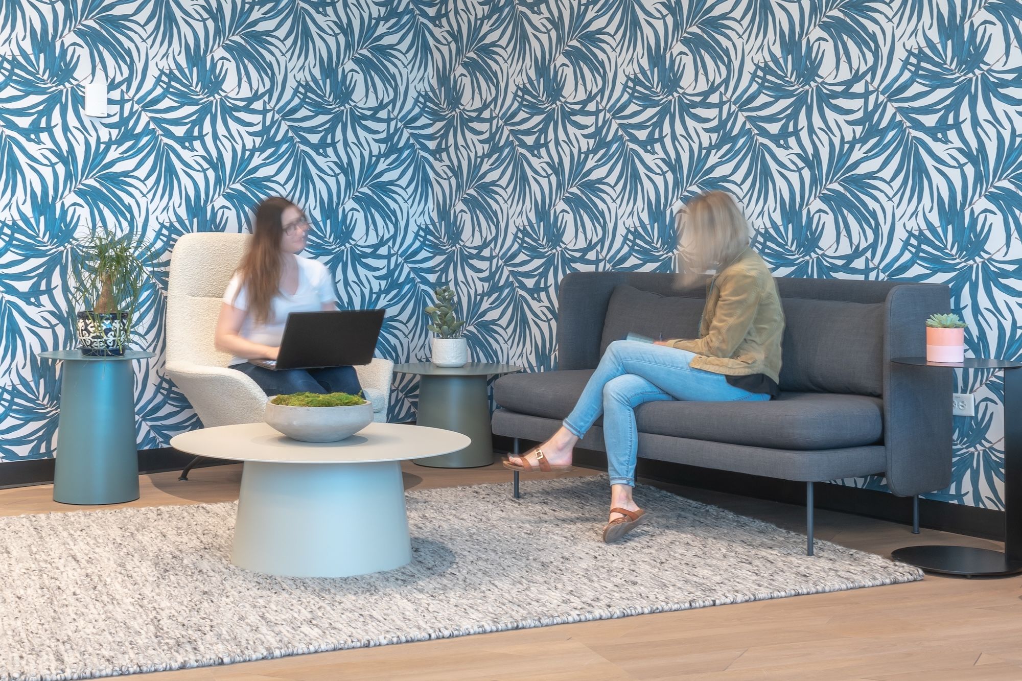 Two workers collaborate in a comfortable space with touches of home.