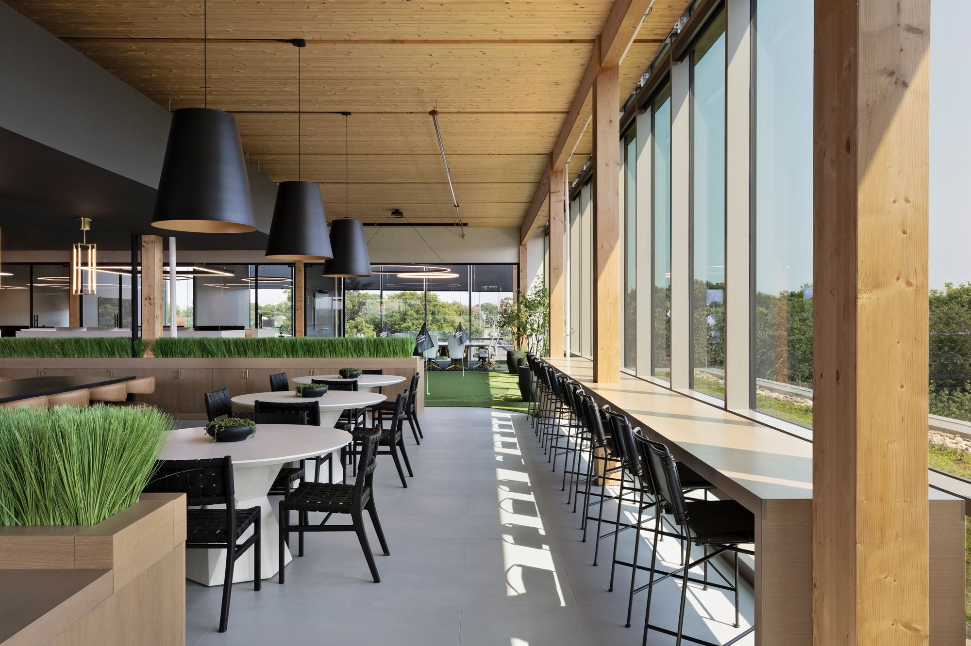 Elmington Property Management office with floor-to-ceiling windows, linear lighting, pendant lights and multiple seating and work areas.