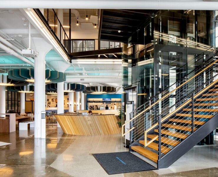You can find several architectural trends for 2023 featured in the Plant Seven coworking space in Highpoint, North Carolina, including rounded pendants, bold pops of color, natural wood finishes, and homey plaid-patterned chairs