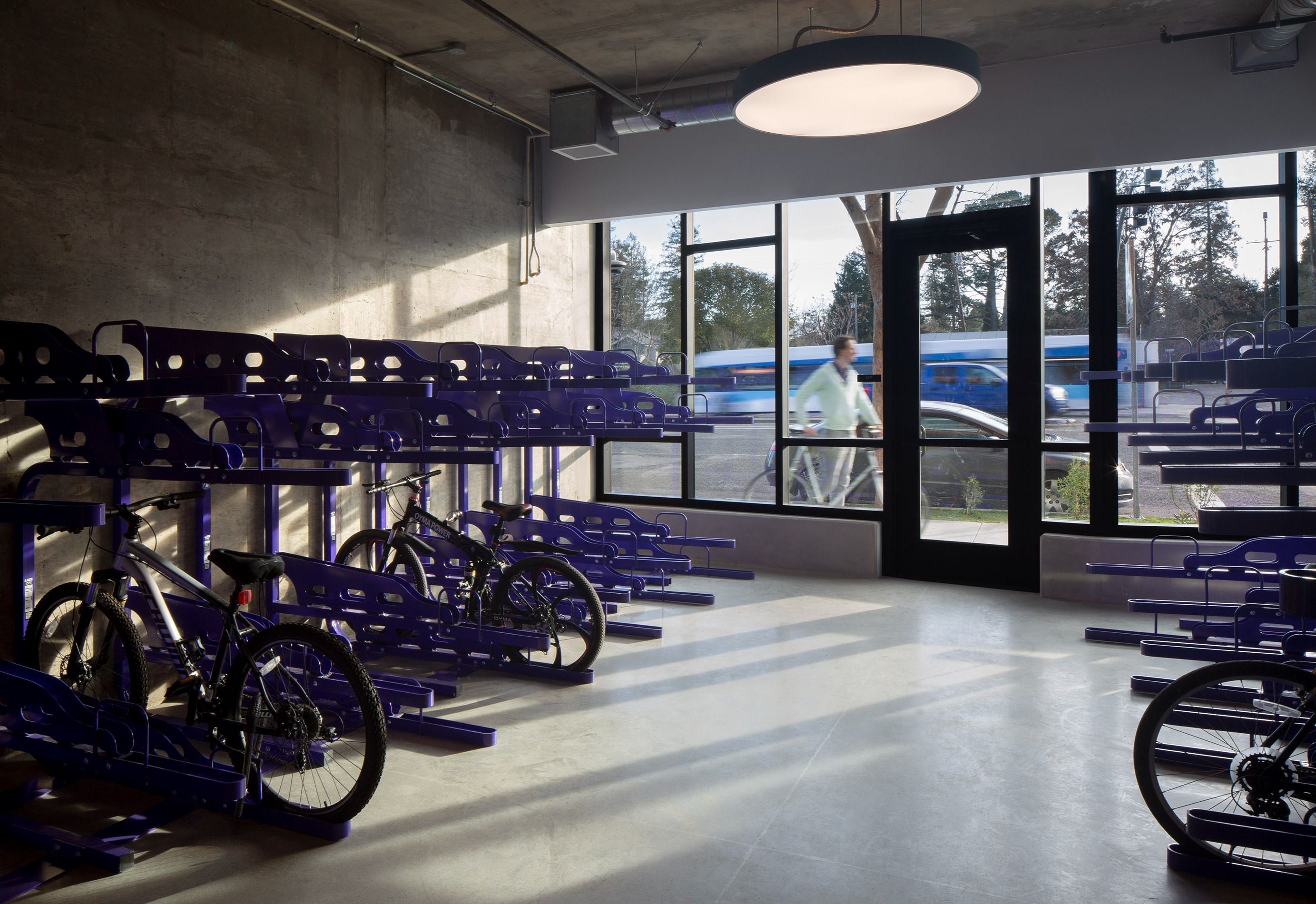 A ring pendant LED light illuminates a bike room at an affordable housing apartment complex with daylight sensors that bring the light up as natural light wanes.