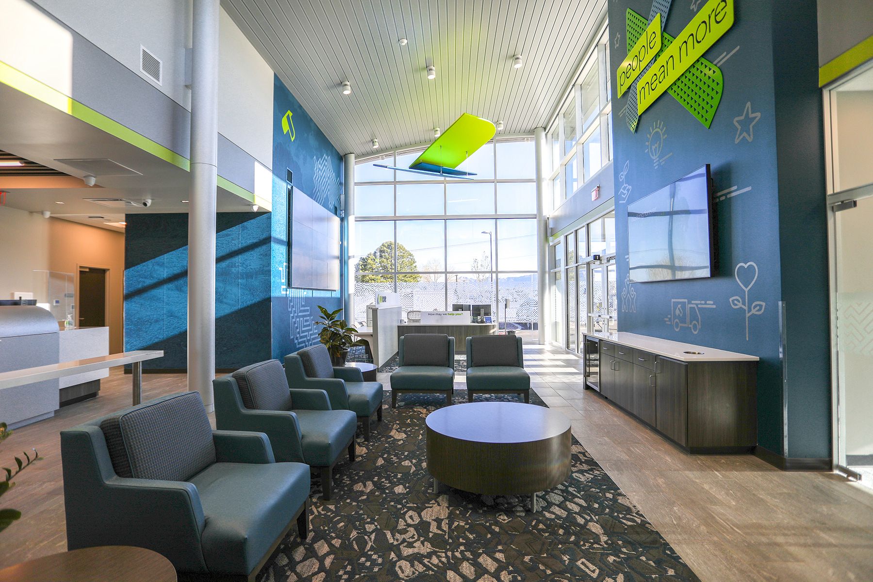 White LED cylinder surface-mount downlights light a credit union lobby, illuminating a contemporary stylized eagle suspended from the ceiling.