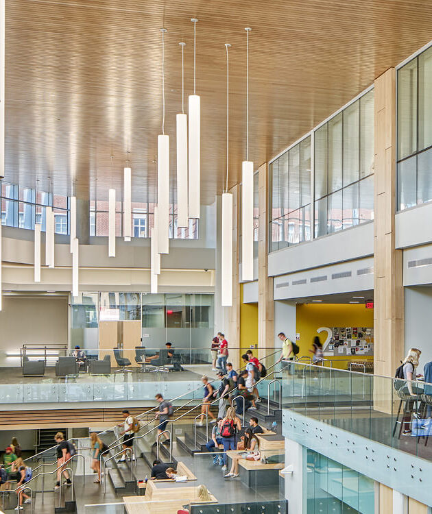 Vertical tube pendant lights suspended at varying heights over the quad of the University of Louisville Belknap Academic Building.