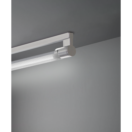 Alcon 12160-S, surface linear ceiling light shown in silver finish, a tubular half-lit trim-less lens, and a curved perforated lens cap.
