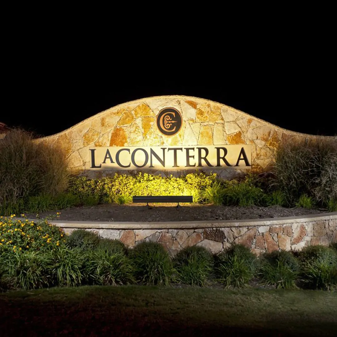 An outdoor LED sign light illuminates the La Conterra subdivision sign at the sub-development entrance in Georgetown, Texas.