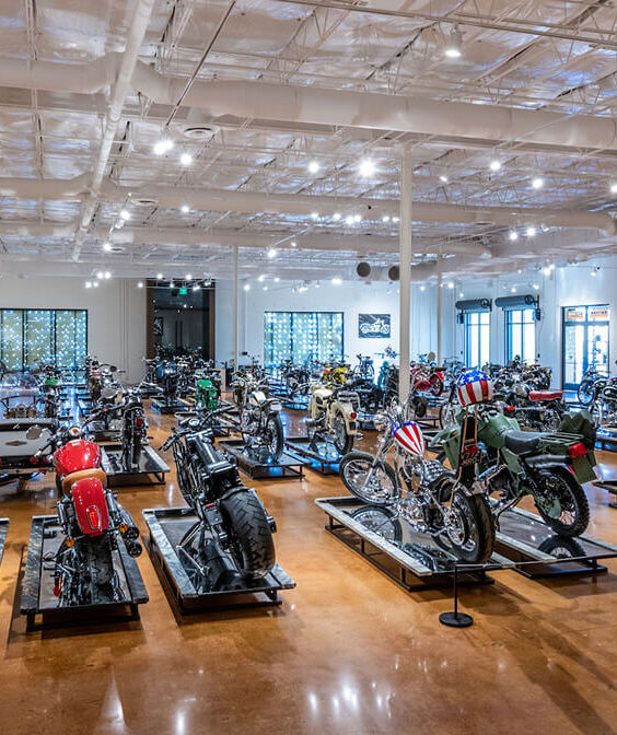 Suspended track-lighting system with adjustable cylinder fixtures in an open-ceiling gallery.