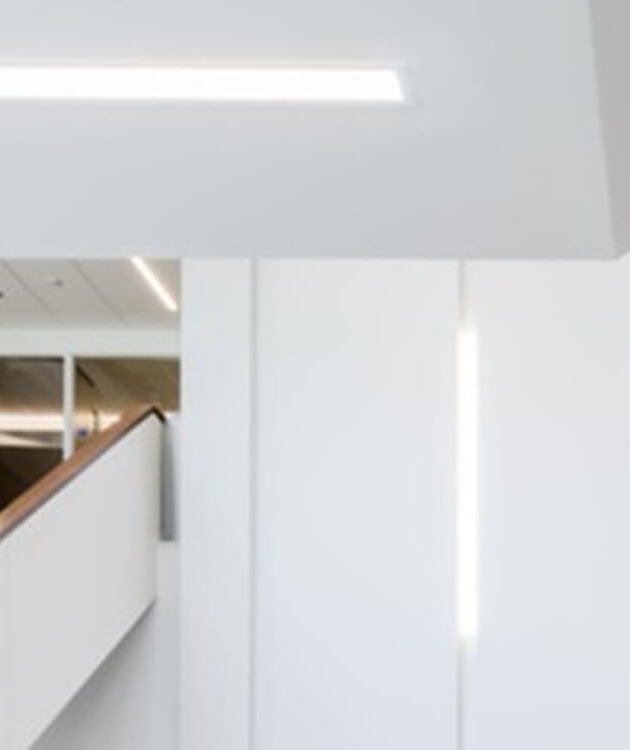Recessed linear lighting extends from the ceiling down the wall inside the FIMS and Nursing Building.