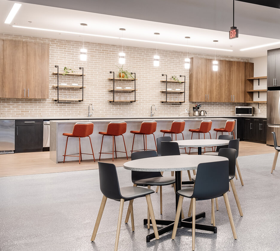 Trimless recessed linear lights define and elevate a kitchen space in a Midwest distribution center.