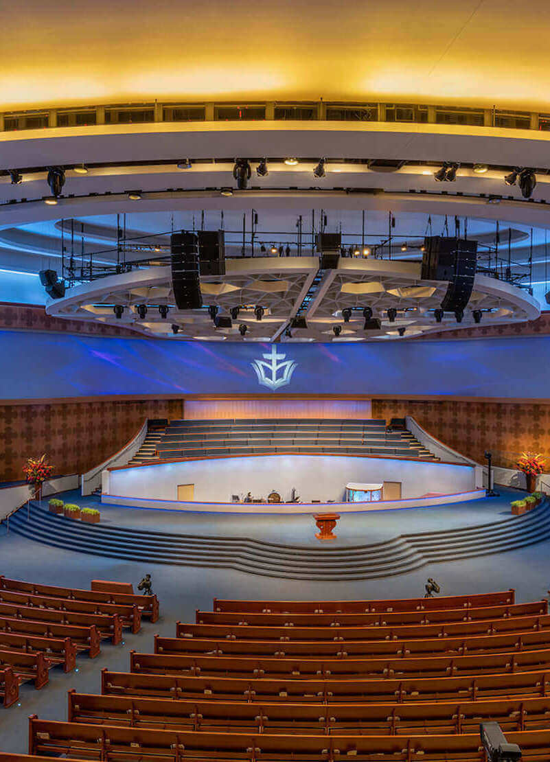 Continuous runs of RGB+W recessed linear lights follow the curves of an expansive modern chapel, washing the walls in a calm blue light.