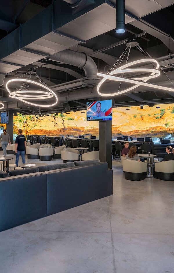 Ring pendant lights suspended at varying angles over a hospitality lounge.