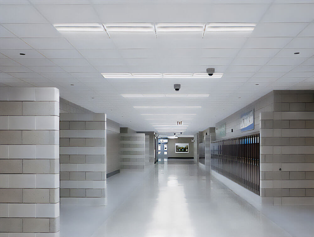 Center basket troffer lights line a school hallway, illuminating lockers down the corridor