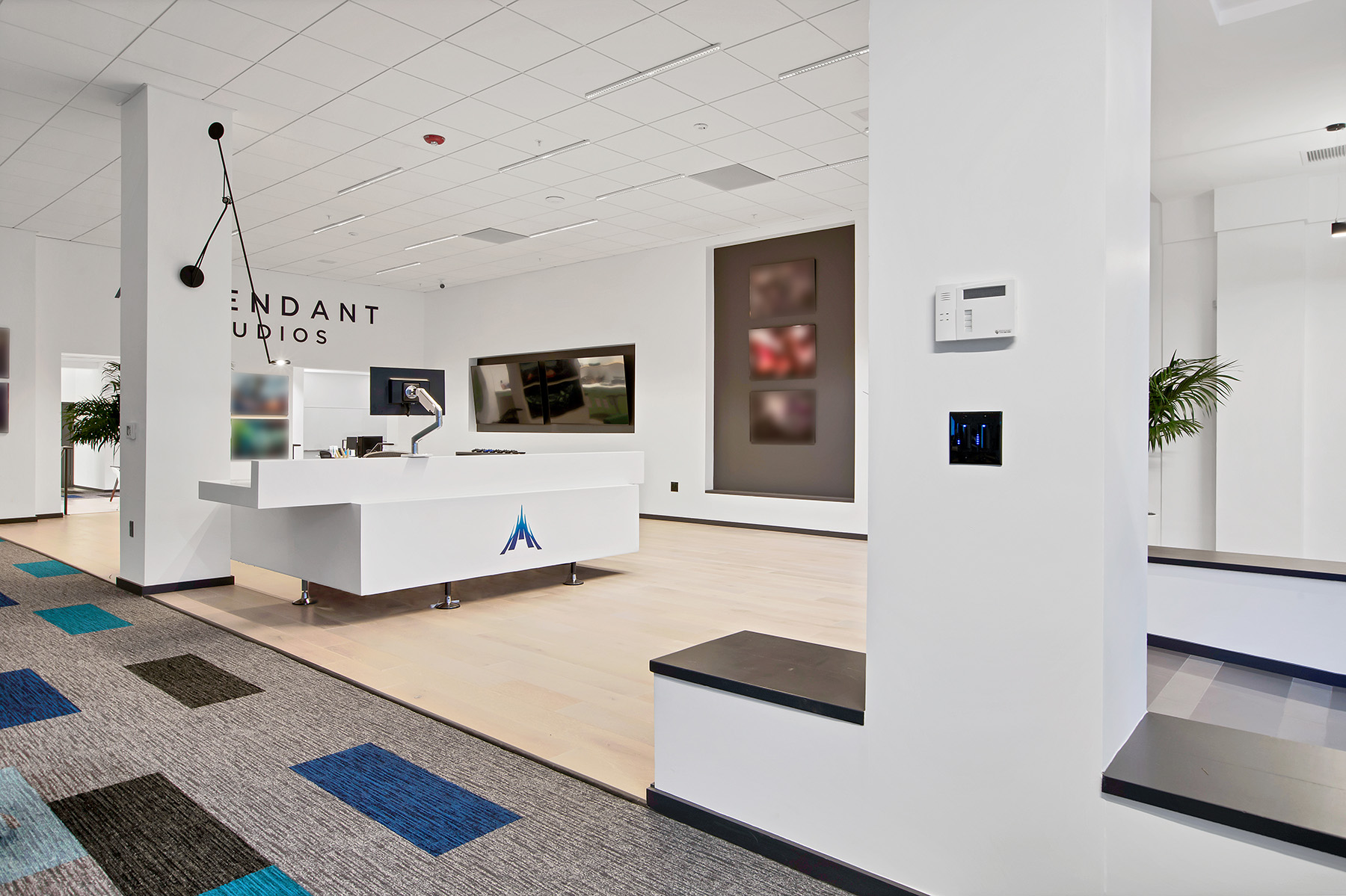 Lighting in the Ascendent Studios lobby includes a wall-mounted task light by the reception space