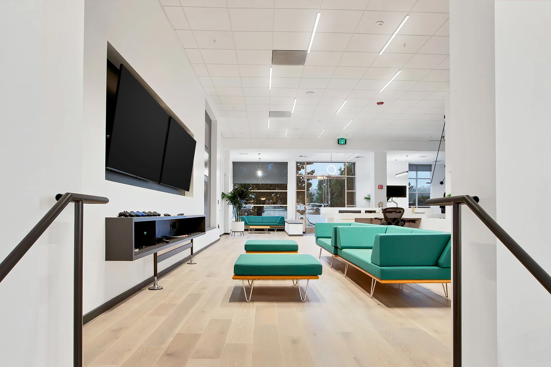 Overhead surface-mount LED lights and linear pendant lighting shown in common areas at Ascendent Studios.