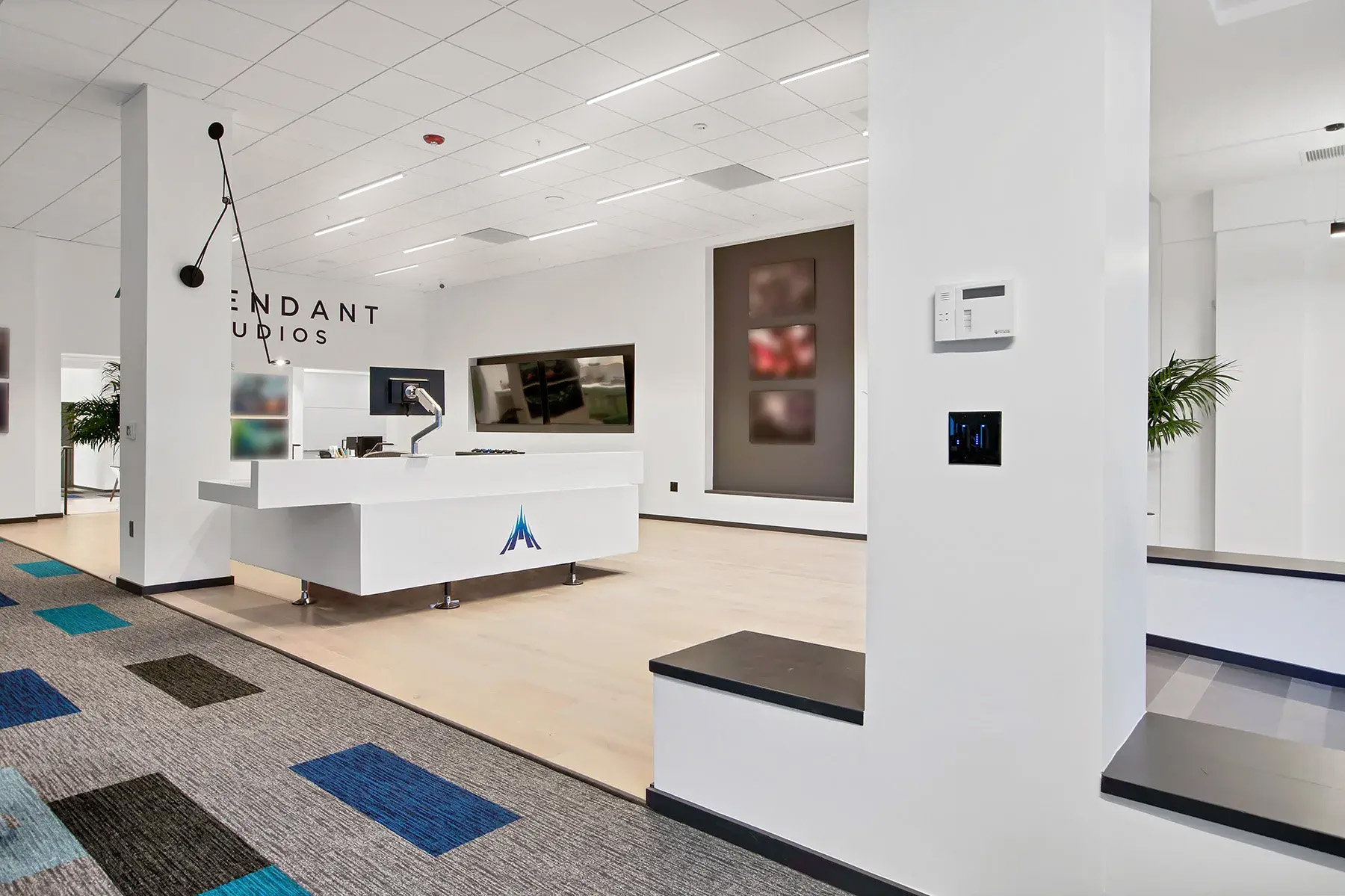 Lighting in the Ascendent Studios lobby includes a wall-mounted task light by the reception space