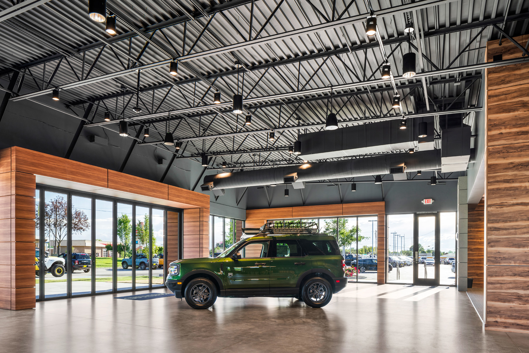 High bay cylinder lighting and a pendant track lighting system illuminate the Kendall Bronco showroom.
 