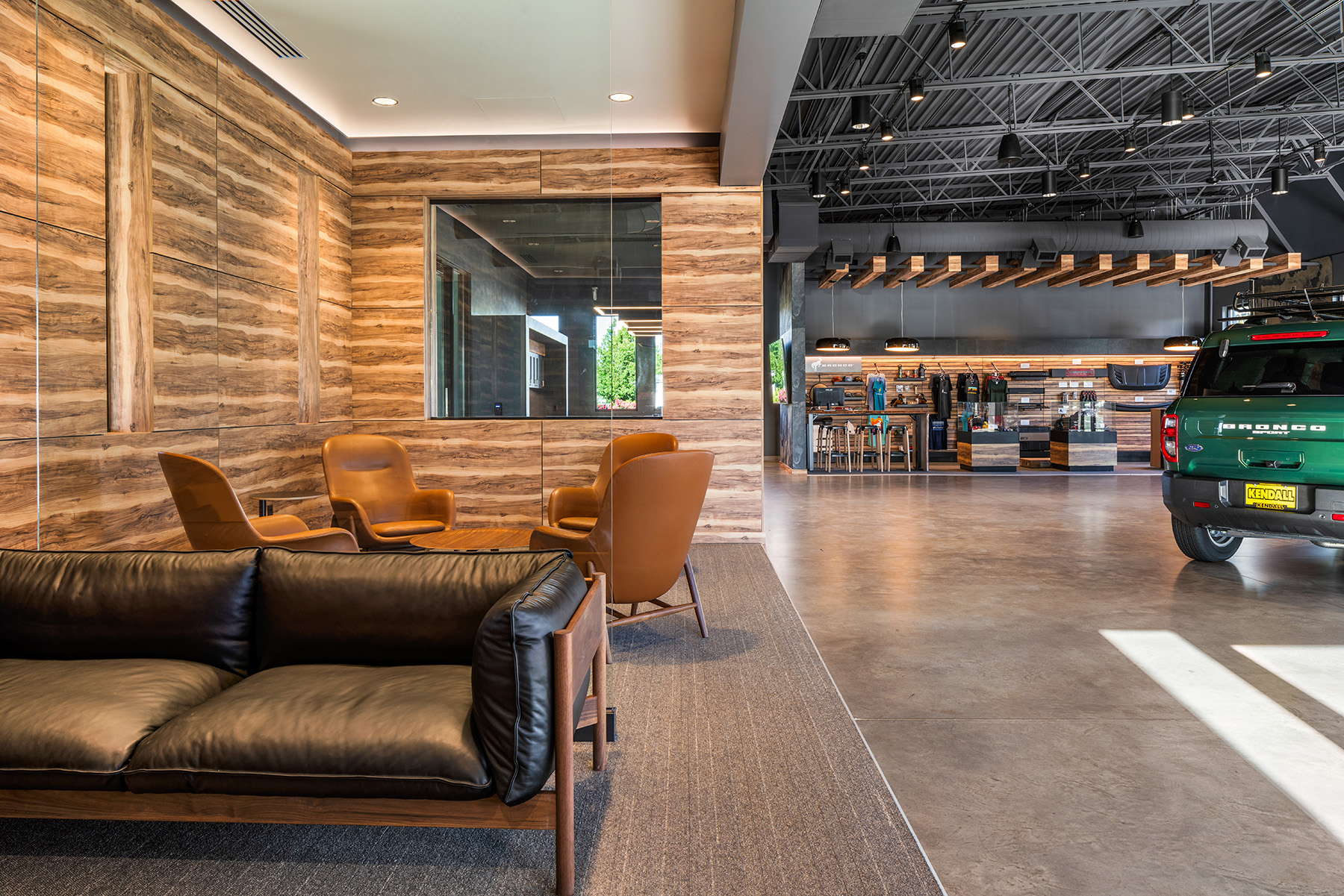 Recessed can lights illuminate a lounge in the Kendall Bronco car dealership, helping to create a space distinct from the main showroom.