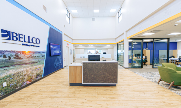 Two-story Bellco Credit Union lobby illuminated by LED troffer lights.