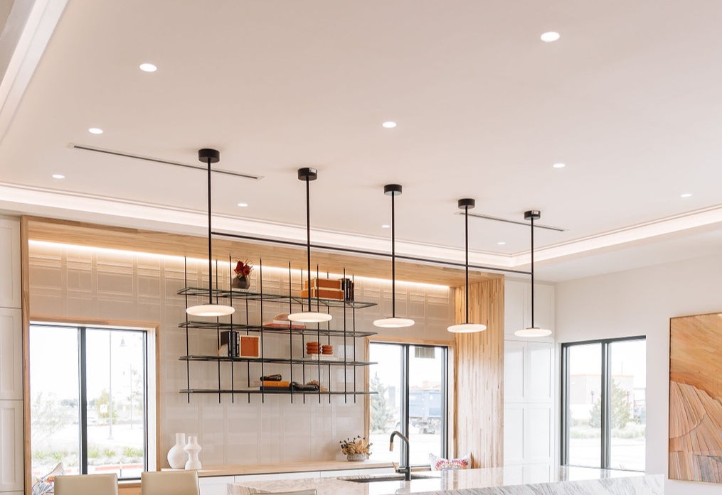 Mud-in LED recessed can lights with frosted lenses light an office kitchen area with a line of LED pendants to provide task lighting over the kitchen island.