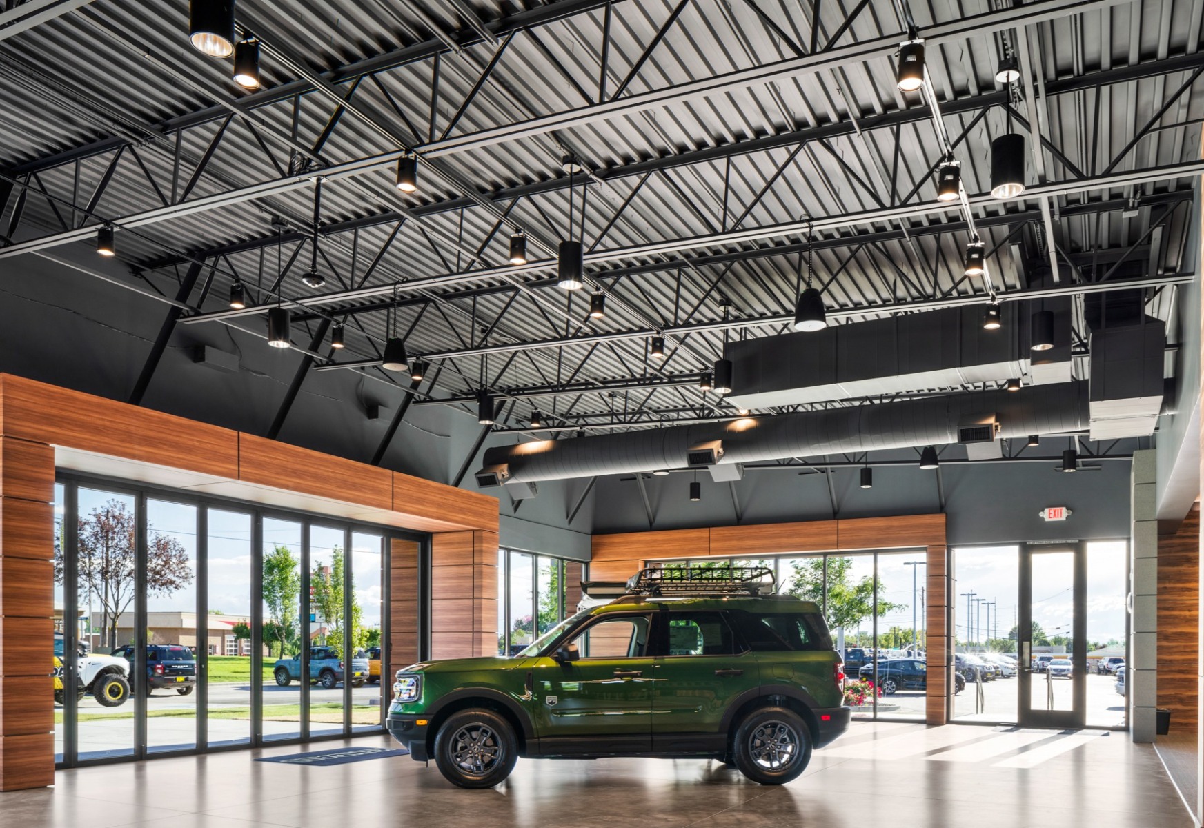 Application of cylinder LED pendant lights over a car dealership showroom.