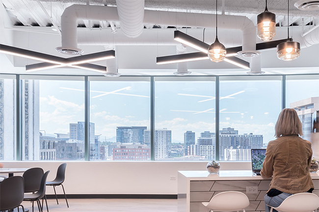 A mix of pendant lights and under-cabinet lighting creates an inviting atmosphere in an office break room.