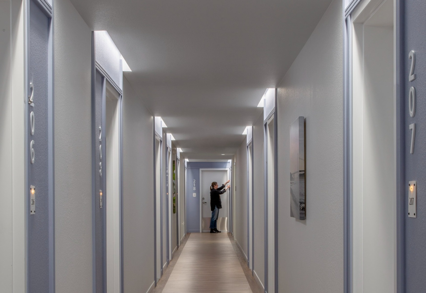 Application of 15233-2 Perimeter LED Recessed Cove Light lighting doorways down an apartment corridor.