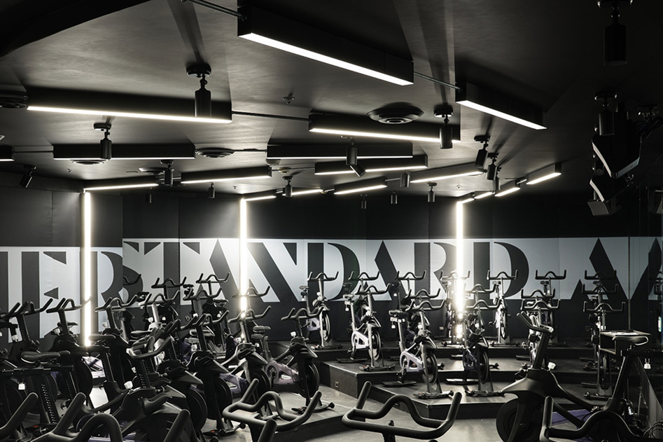 A fanned pattern of linear surface mount and recessed LED lights create a sense of motion, like a spaceship jumping to hyperspace in this spin class.