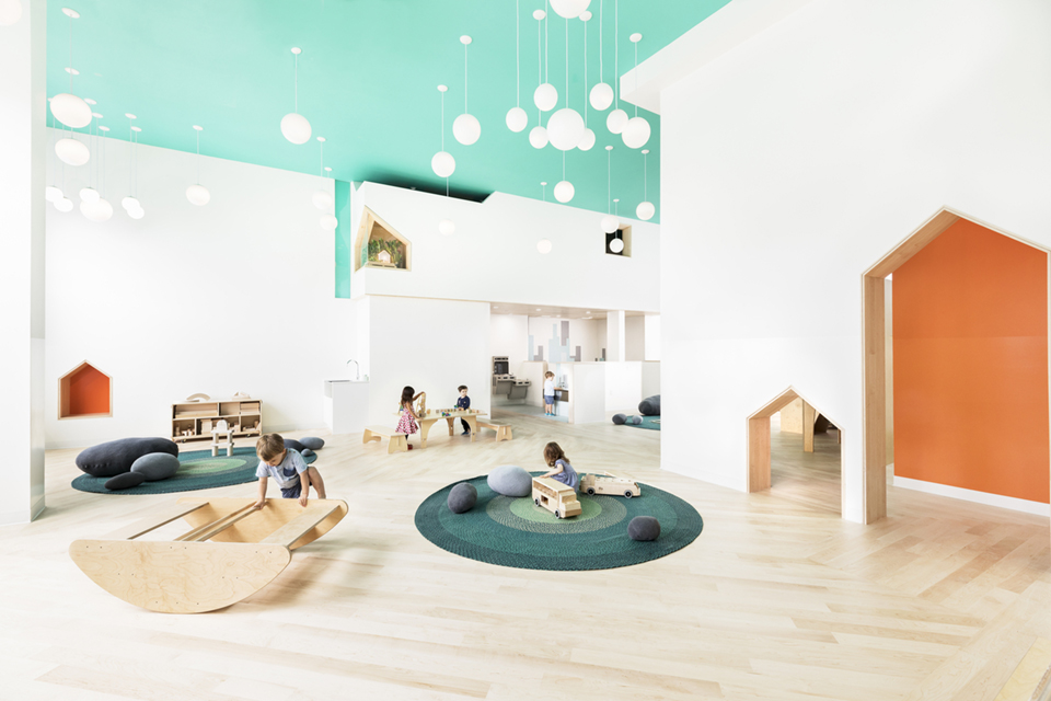 Globe pendant lights hang above a children's playroom at a daycare center