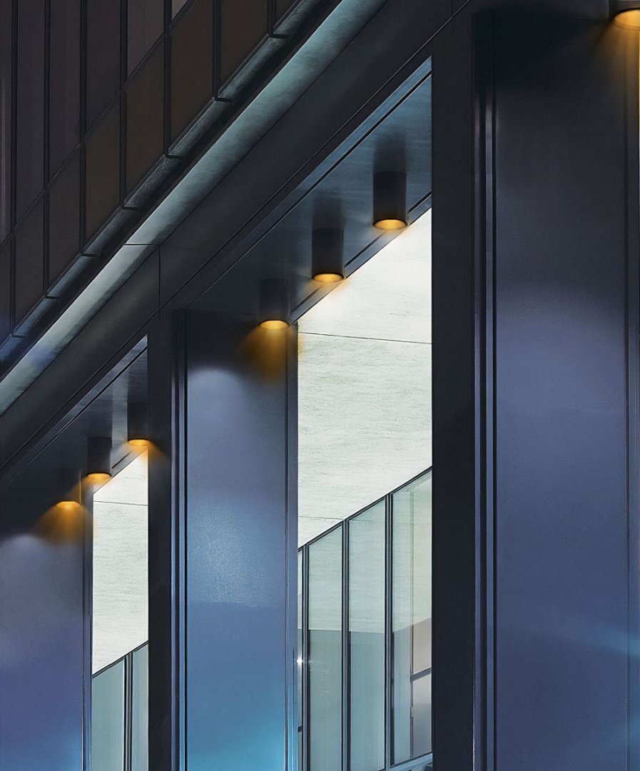 Turtle-safe outdoor cylinder lights line an office building window in an
 area with Dark Sky compliance requirements.