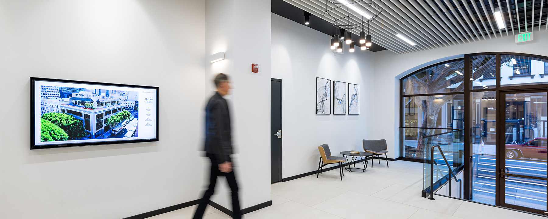 Office lobby lighting at 735 Montgomery Street creates layers of light with wall-mounted up and down lights, pendant lighting and linear ceiling lighting.