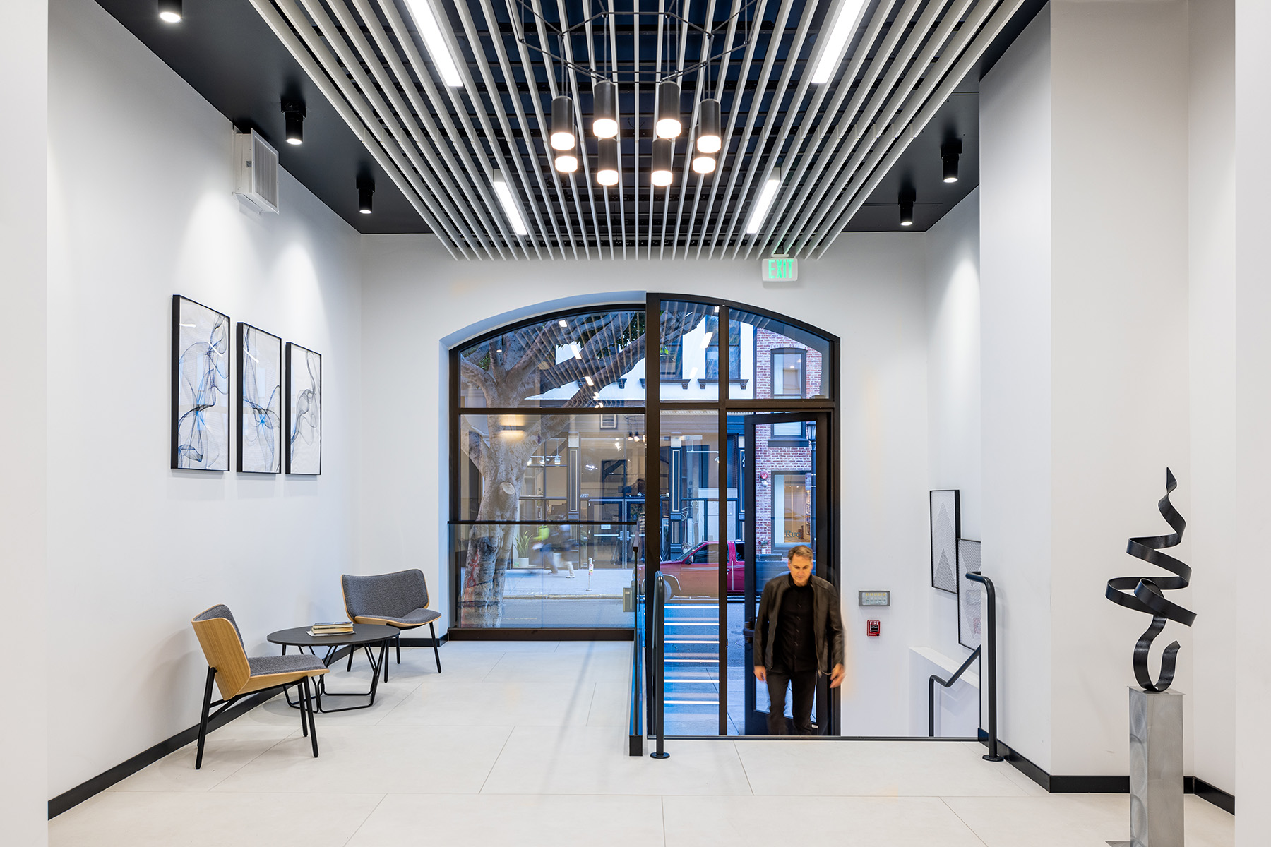 Using linear, pendant and surface mount downlights on the ceiling, designers created layers of light in an office lobby with street-facing windows.