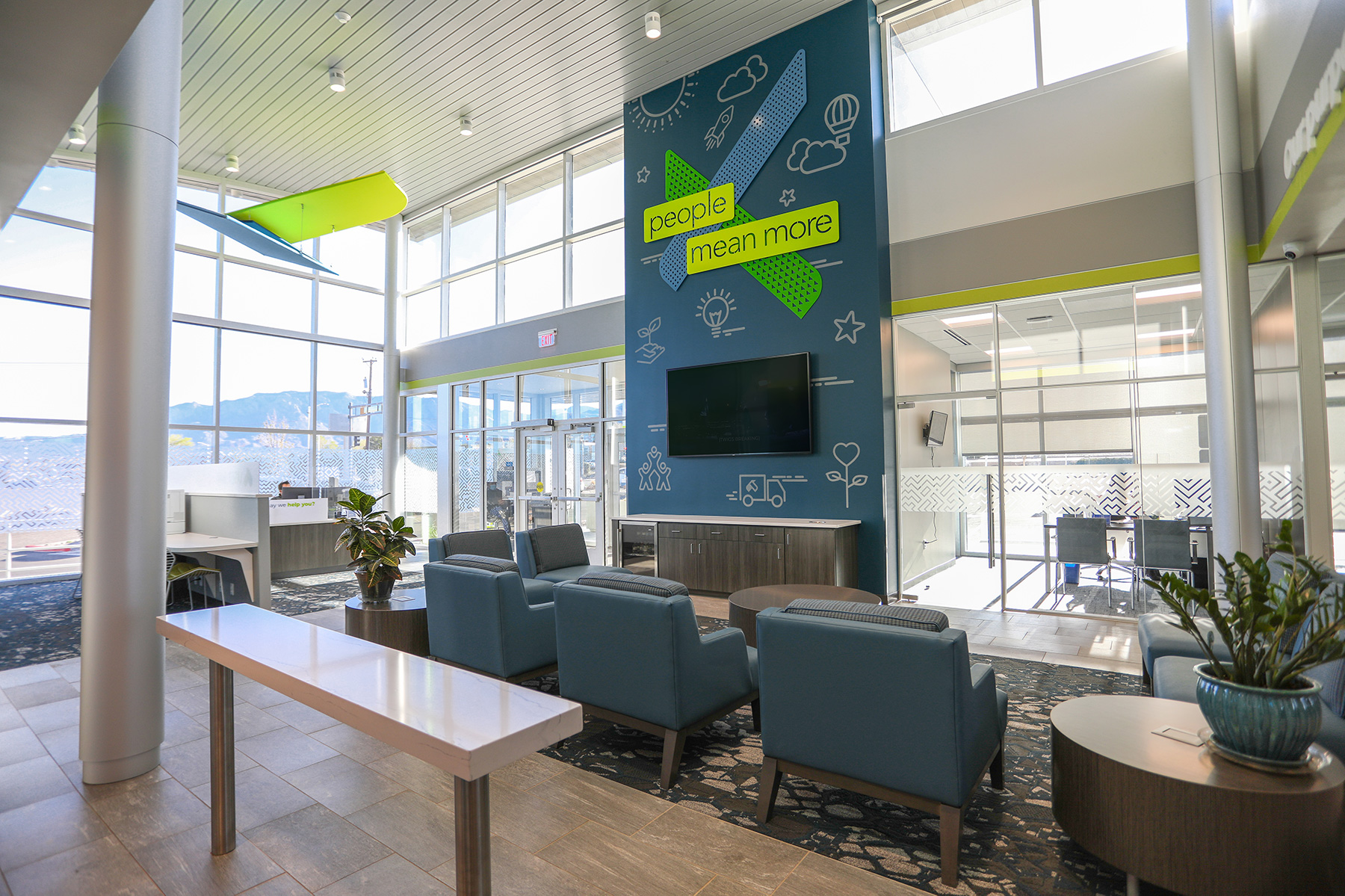 Surface-mounted downlights on a credit union lobby’s high ceiling provide lighting while reducing screen glare to encourage the use of technology.