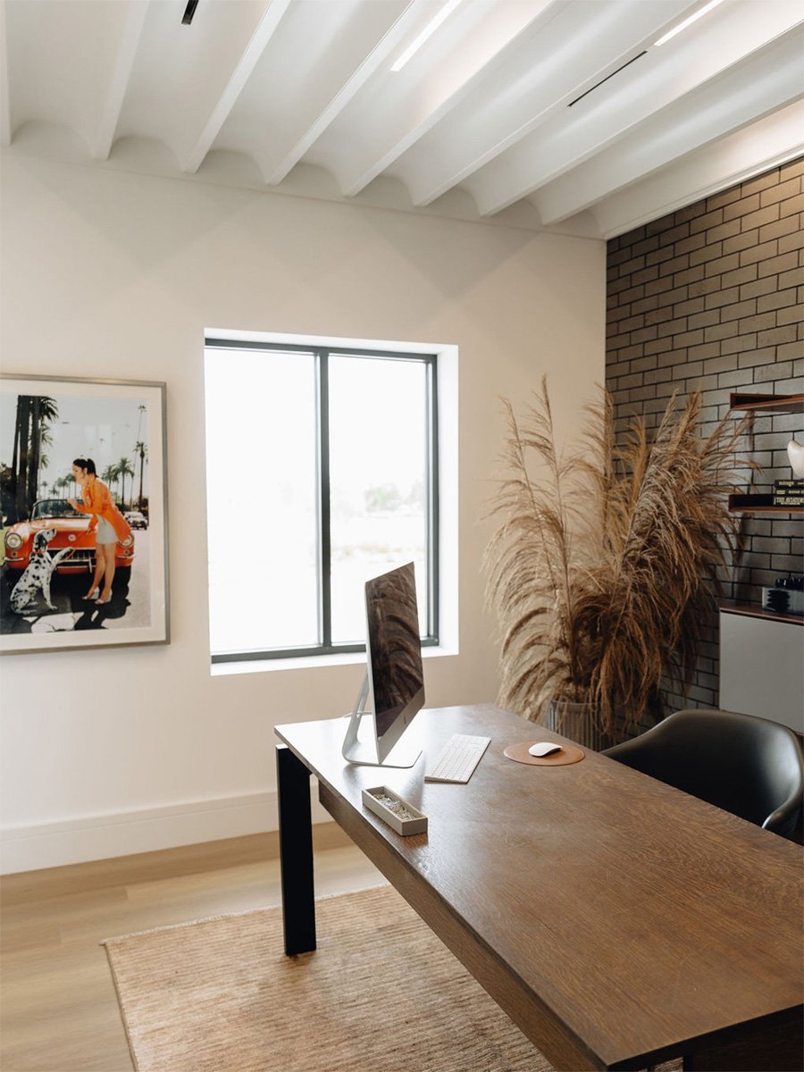 Natural light streams through a window at the HBHQ podcast studio office with linear recessed LED lights providing downlighting and wall wash lighting