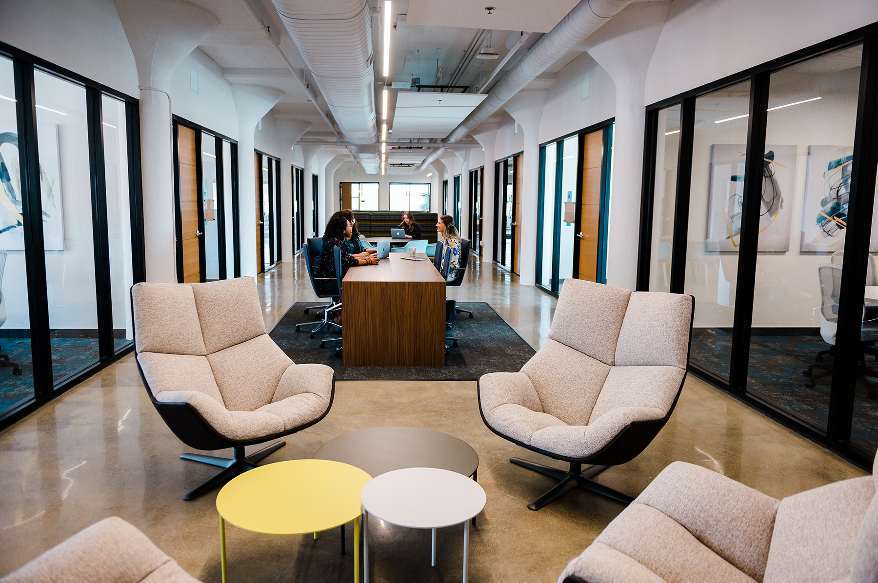 A line of stainless-steel pendants enhances the industrial feel of a millwork factory converted into an office space.