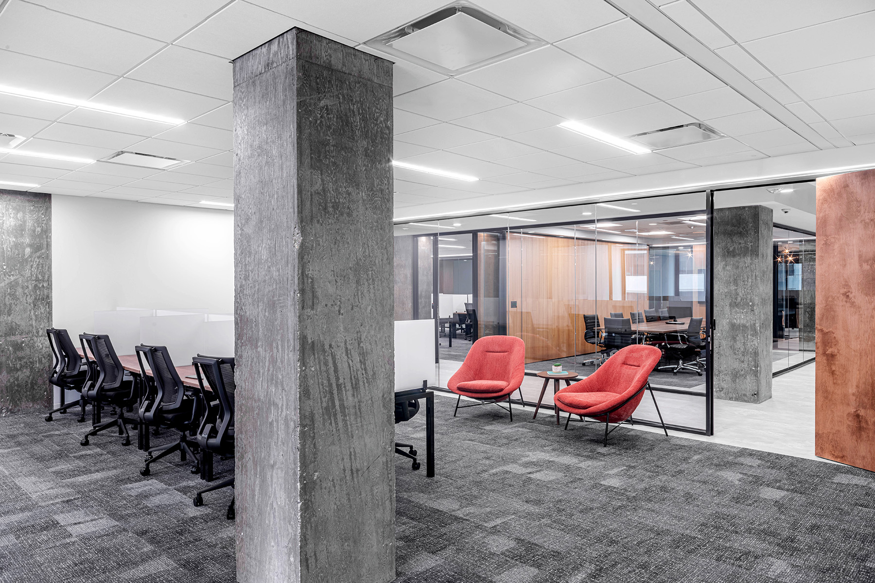 Linear recessed lights fitted in a grid ceiling light a communal workspace and social area.
