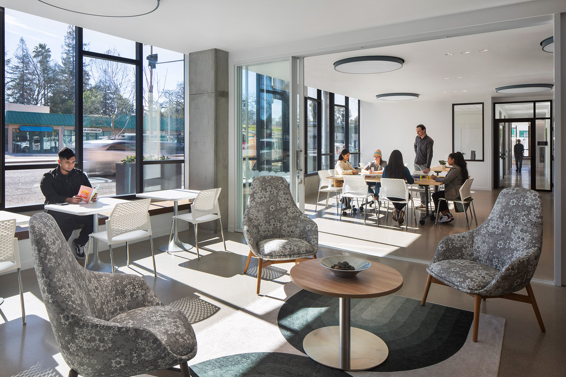 Surface-mounted disk lights and recessed can lights illuminate a common room at Wilton Court Apartments in Palo Alto, California.