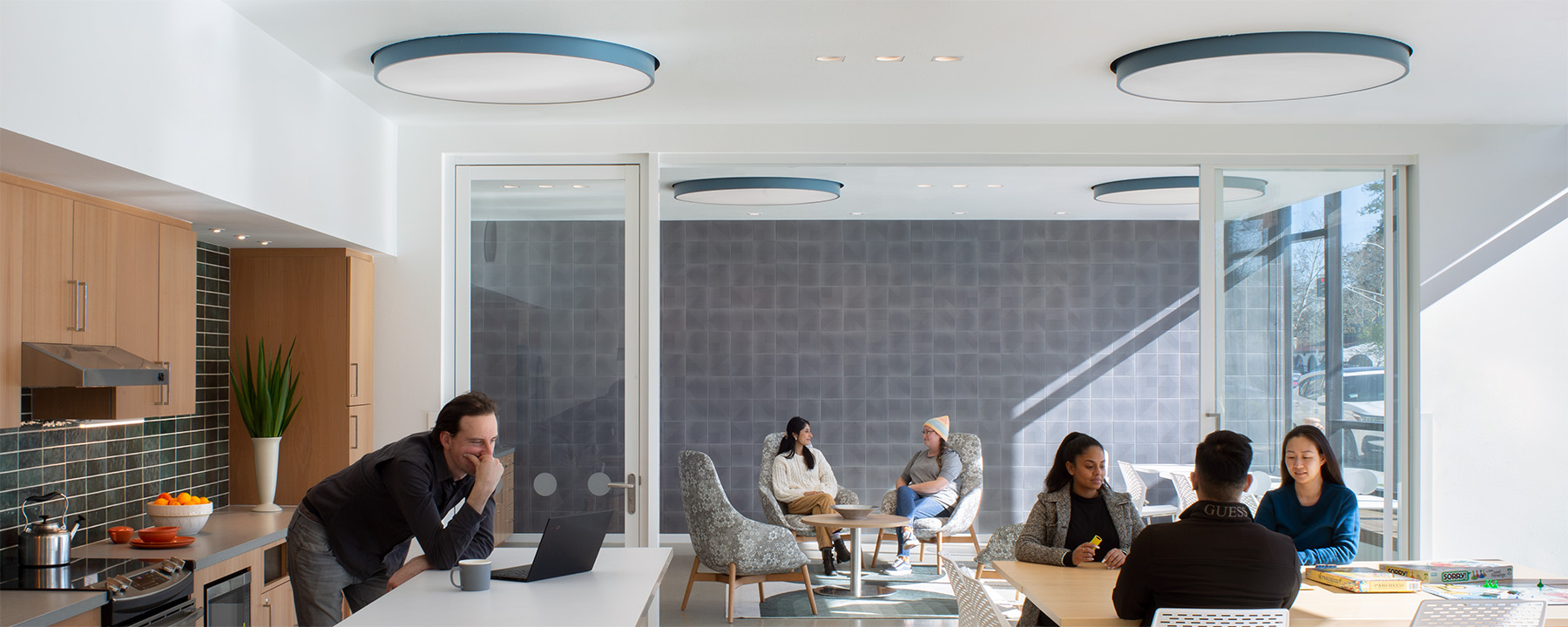 Lighting in the Wilton Court Apartments common room in Palo Alto, California takes advantage of ample natural light from windows facing the street.